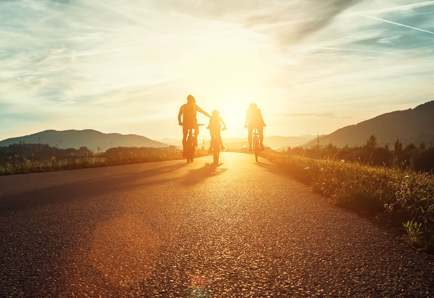 Family biking into sunset 